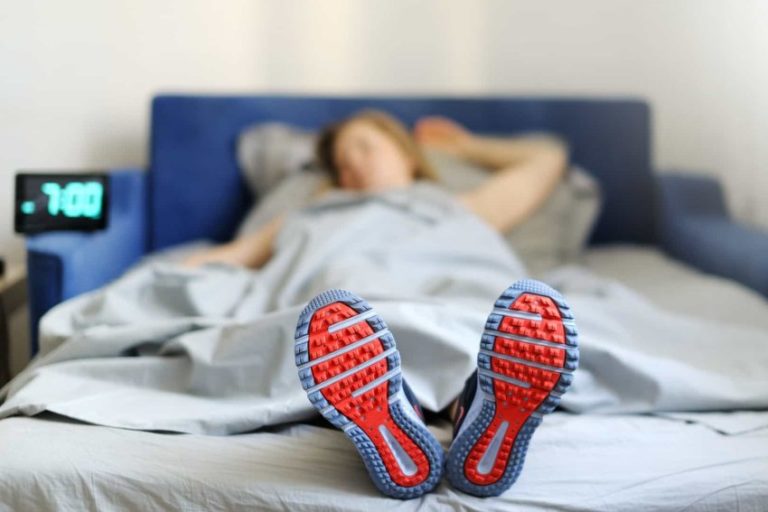 Бессонница после тренировки. Спит в кроссовках. В кроссовках на кровати. Сон спортсмена. В обуви на кровати.